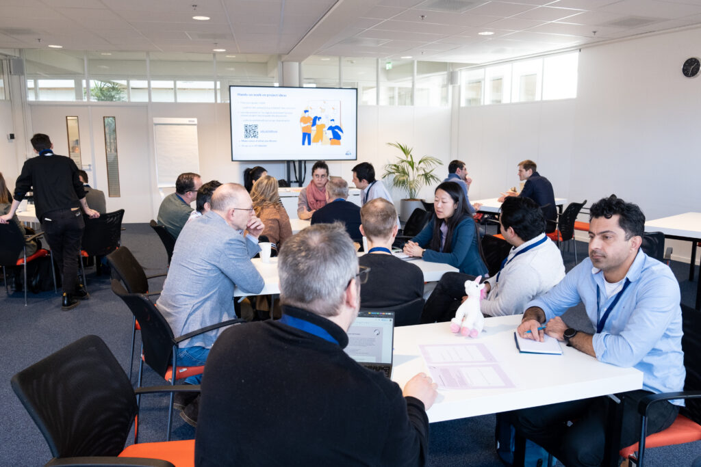 Photo of session attendees, sitting around a table, engaged in a discussion 