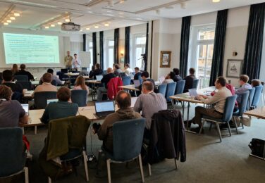 A session from the Ontologies4Chem workshop, with two speakers presenting and the attendees carefully listening
